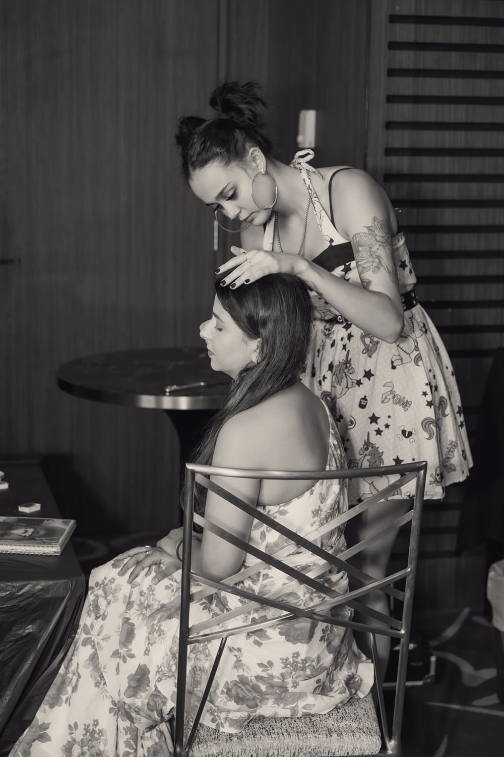 Gaia painting a seated client's hairline at an event