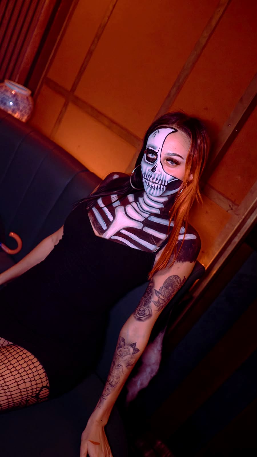 Skeleton body paint under red club lighting