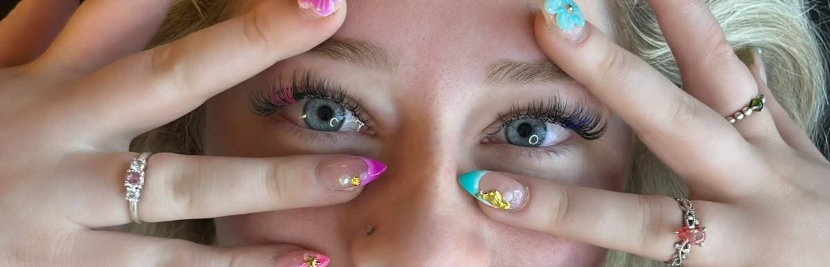 A finished lash set, framed by hands with painted nails