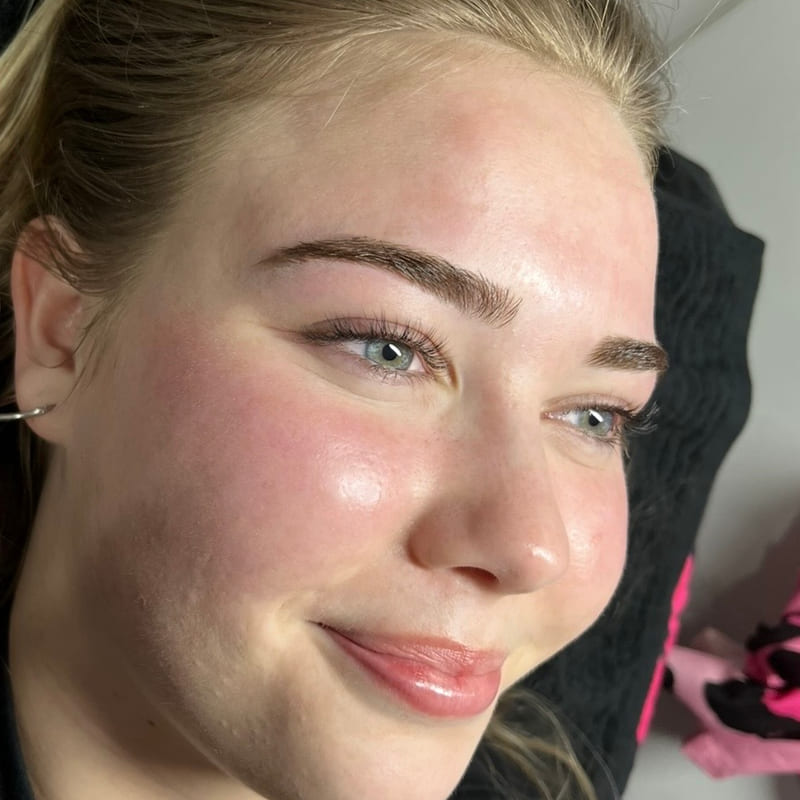 Laminated brows and lash extensions on a smiling client